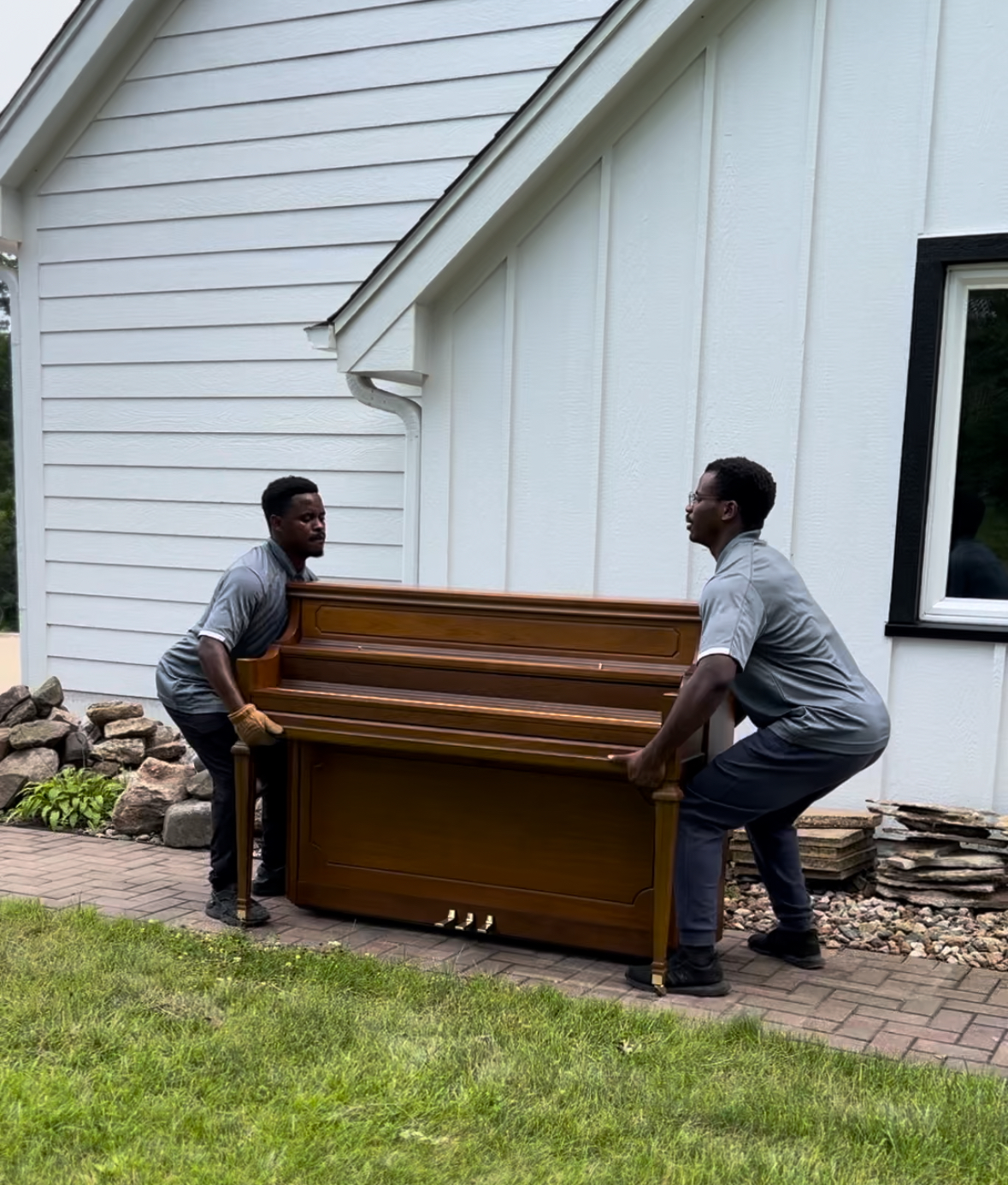 Midwest Moving Pros crew safely moving a piano with specialty equipment at a Des Moines home.